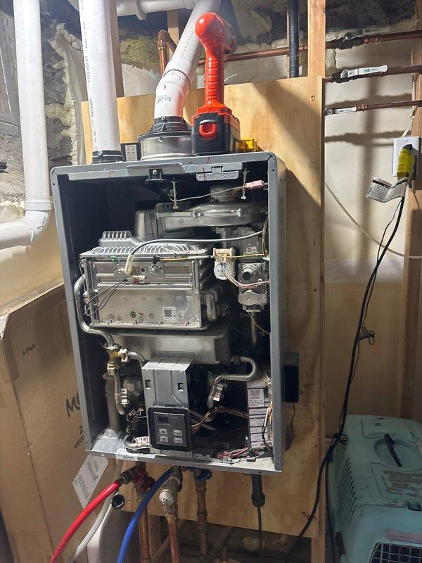 Performed scheduled maintenance on tankless water heater system, including complete descaling flush to remove mineral buildup and ensure optimal performance. Removed front access panel to access internal heat exchanger components, connected flushing equipment, and circulated descaling solution through the unit to eliminate calcium and sediment deposits from the heat exchanger fins and water pathways. Inspected water filtration system with dual black filter canisters to verify proper pre-filtration of incoming water supply, which helps extend the life of the tankless unit. Verified all inlet and outlet connections, including hot water supply line, cold water return, and gas line connections for proper sealing and operation. Restored unit to normal operating condition and confirmed proper functionality of digital control modules and venting system upon completion of maintenance service.