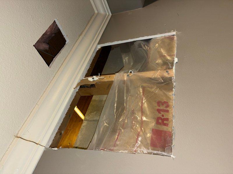 Responded to service call for exterior spigot that had blown out and was leaking back into the house when used. Accessed interior wall and attic space to locate the failed connection point where the outdoor faucet line penetrated the building envelope. Replaced damaged section of water line with new white PEX piping and brass compression fittings, properly securing the pipe through the wooden framing members. Created wall access point to reach the compromised plumbing, exposing R-13 insulation and vapor barrier to complete the repair. Tested the outdoor spigot for proper operation and verified no water was leaking back into the interior spaces.