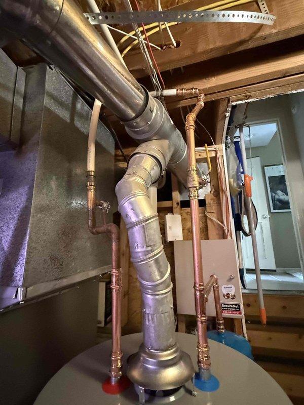 Completed installation of a 50-gallon gas-fired water heater with thermal expansion tank in basement utility space. Installed new copper supply piping connections with proper fittings and joints, secured all plumbing lines to structural framing using appropriate metal strapping per code requirements. Integrated thermal expansion tank into the cold water supply system to protect against pressure buildup from thermal expansion. All gas connections, water supply lines, and pressure relief discharge piping installed according to manufacturer specifications and local plumbing codes. System tested for proper operation, verified gas connections for leaks, and confirmed adequate venting through existing ductwork. Installation completed within 30-minute notice timeframe with all components properly secured and functional.
