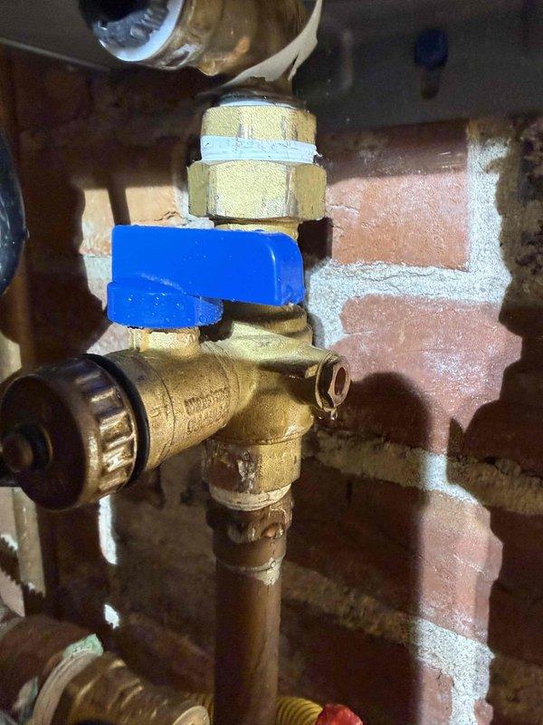 Responded to no hot water complaint on second floor. Upon arrival, inspected tankless water heater installation and associated plumbing connections mounted against brick wall. Evaluated gas supply line with yellow flexible connector, water supply lines with isolation valves (blue and red handles), and electrical connections. Diagnosed issue with water flow or gas supply affecting unit operation. Verified proper valve positions, checked brass ball valve and compression fittings for functionality, and ensured gas line connections were secure per manufacturer specifications. Restored hot water service to second floor. System tested and confirmed operational upon completion.