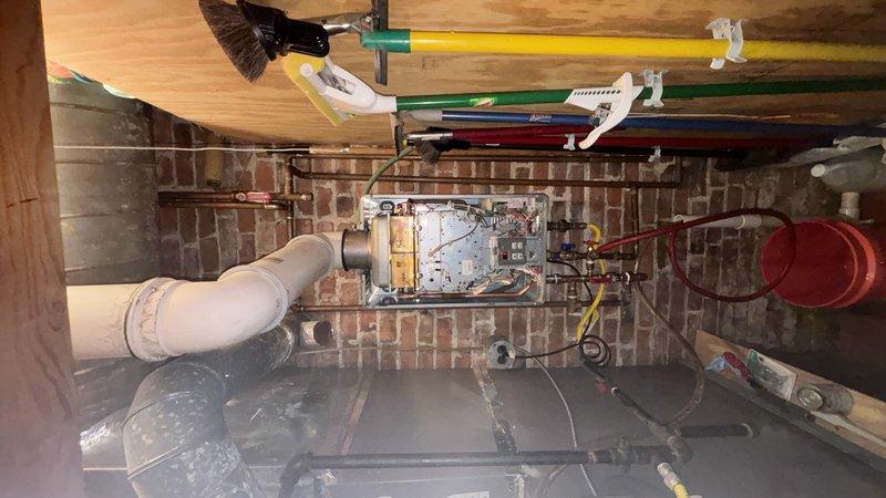 Installed service ports on Rinnai RL75 tankless water heater unit located in basement utility area. Technician coordinated availability and completed the installation, which enables future maintenance access and servicing of the unit's isolation valves for flushing and descaling procedures.