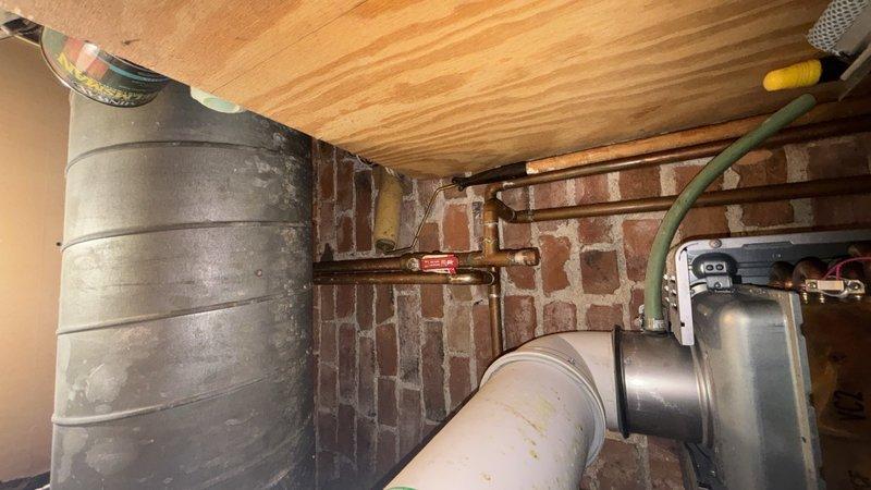 Installed service ports on Rinnai RL75 tankless water heater unit located in basement utility area. Technician coordinated availability and completed the installation, which enables future maintenance access and servicing of the unit's isolation valves for flushing and descaling procedures.