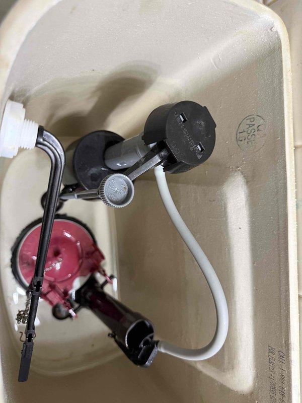 Completed toilet tank component replacement including installation of new fill valve assembly, water supply line, and supply stop valve. All components were properly seated and secured within the tank, with connections tested for proper operation and water-tight seals. The flush mechanism was verified to function correctly with the new fill valve system.
