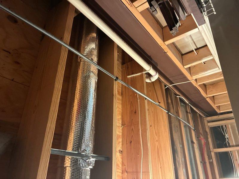 Completed comprehensive plumbing inspection of residential property during rough-in construction phase. Examined exposed PVC drainage system including Schedule 40 piping installations, verified proper routing and support of supply lines, and assessed coordination between plumbing infrastructure and HVAC ductwork in ceiling cavity. All visible components appear to be properly installed with adequate clearances maintained between systems.