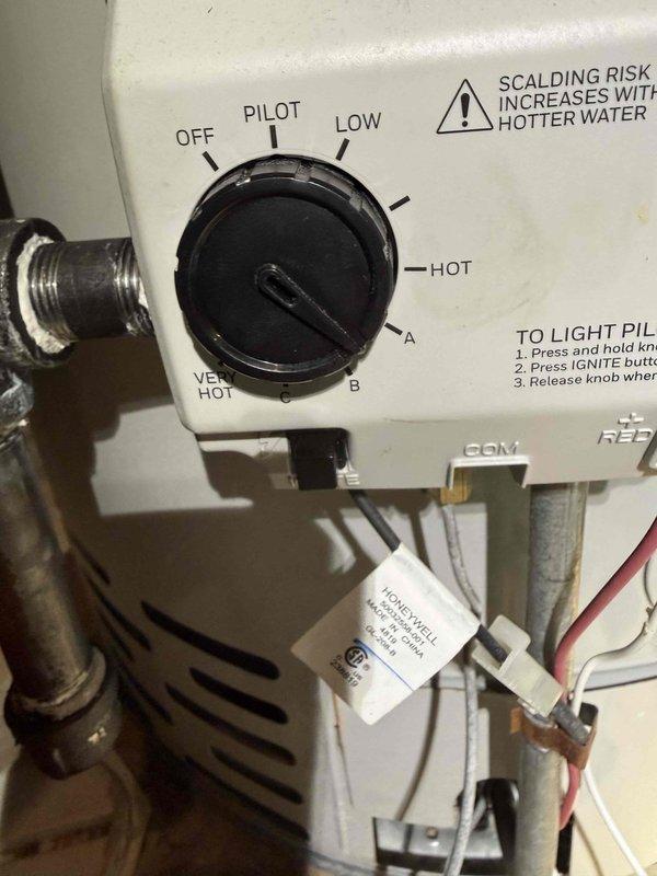 Responded to customer report of water heater producing only lukewarm water in basement. Upon inspection, found Bradford White Defender Safety System tanked water heater with gas control valve set to LOW position. Verified pilot light was lit and burner assembly functional. Adjusted temperature control dial from LOW to HOT setting to restore proper water heating capacity. Confirmed proper operation of gas valve and thermostat controls. Unit returned to normal operating temperature range.