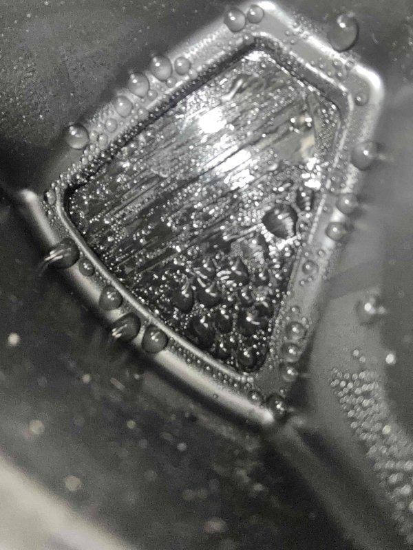 Responded to warranty callback for water pooling beneath recently installed water softener unit. Upon inspection, discovered water accumulation in the drain pan with visible sediment and debris, indicating a drainage issue. The condensate collection tray showed standing water with cloudy discoloration and corrosion along metal edges. Identified drainage obstruction preventing proper water evacuation from the system. Cleared blockage, tested drain flow, and verified proper operation of the water softener drainage system to resolve pooling issue.