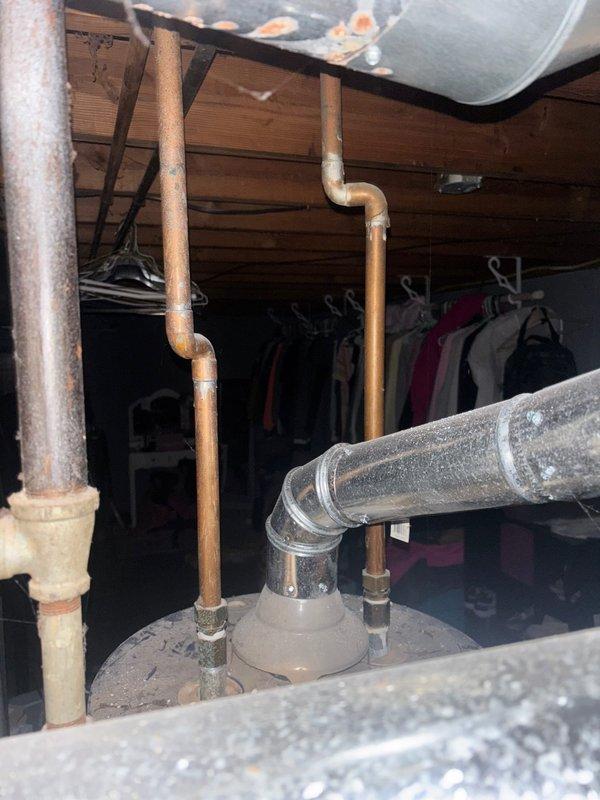 Responded to service call for water heater with pilot light that would not remain lit. Upon inspection, determined that repair was not viable and proceeded with full replacement of existing tanked water heater. Removed old 50-gallon residential water heater from utility closet adjacent to Trane furnace unit. Disconnected existing gas line, cold water supply, and hot water outlet connections. Installed new 50-gallon tanked water heater in same location. Connected gas supply piping using black iron pipe, ensuring proper threading and joint sealing. Attached copper water supply lines with appropriate brass fittings and verified all connections were secure. Installed temperature and pressure relief valve with proper discharge piping. Lit pilot light, tested burner operation, and verified proper ignition sequence. Checked all gas connections for leaks using approved detection methods. Confirmed adequate combustion air supply and proper venting. Set thermostat to manufacturer recommended tem