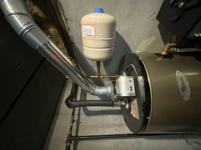 Completed comprehensive whole-home plumbing inspection including water heater flush service. Inspection revealed mineral buildup and sediment accumulation in toilet tank with discolored water present; all tank components including fill valve, flapper, and flush mechanism found functioning properly despite age-related staining. Water heater system, expansion tank, and associated copper piping connections inspected and confirmed in good working condition.