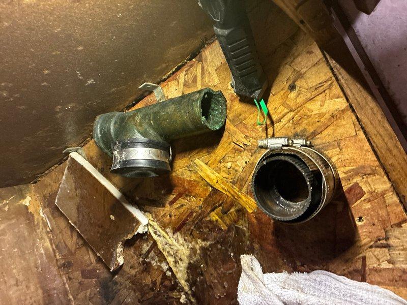 Responded to a kitchen drain line failure in the crawlspace area. Upon inspection, identified a deteriorated galvanized tee fitting showing significant corrosion and age-related degradation that required immediate replacement. Removed the failed galvanized tee section and repaired the drain line by installing a straight run of PVC pipe to restore proper drainage function. Work was completed in the underfloor area among existing plumbing infrastructure and wooden floor joists.