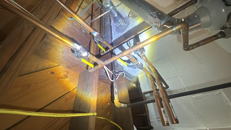 Performed water heater estimate for an 18-year-old unit experiencing pilot light ignition failure. Assessed existing installation, photographed current plumbing configuration including copper supply lines and venting system, and determined unit has reached end of serviceable life requiring replacement.