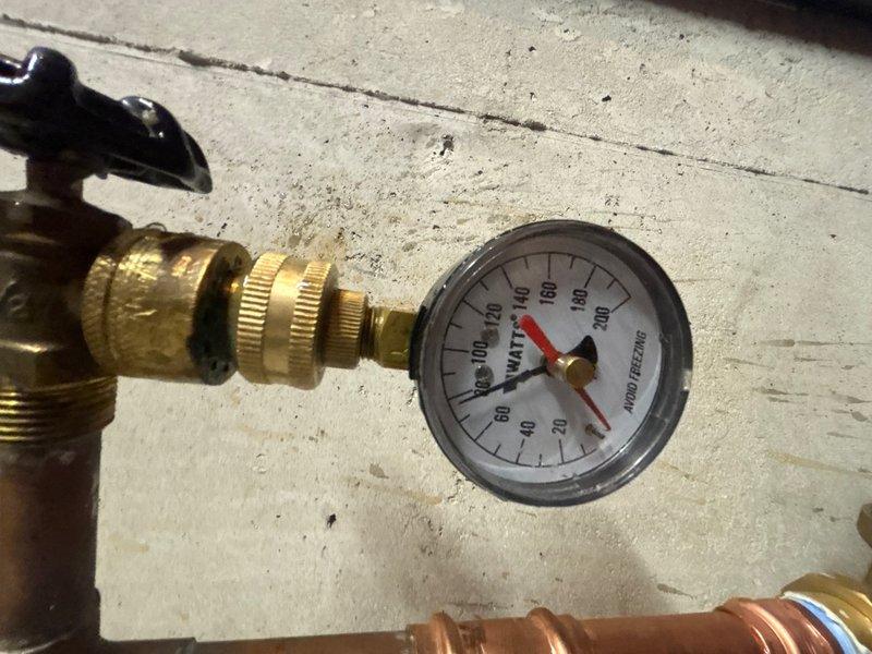 Installed customer-supplied pressure reducing valve (PRV) on main water line with brass fittings and shut-off valves. System tested and verified proper operation with pressure gauge reading approximately 90 PSI, ensuring adequate water pressure regulation for the property.