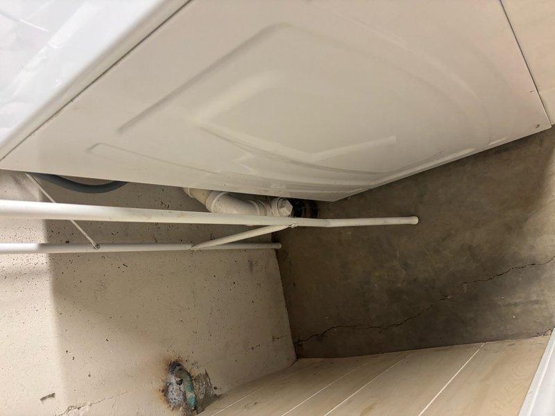Responded to clogged drain issue at lowest level of property. Upon inspection, located floor drain in utility area near water heater showing signs of corrosion and restricted flow. Previous liner installation by another company was noted in service history. Accessed drainage system behind laundry appliances where multiple PVC supply and drain lines were present. Performed diagnostic assessment of drainage infrastructure, identifying blockage in floor drain assembly. Cleared obstruction and restored proper drainage function. Verified water flow through system and confirmed resolution of reported clogging issue.