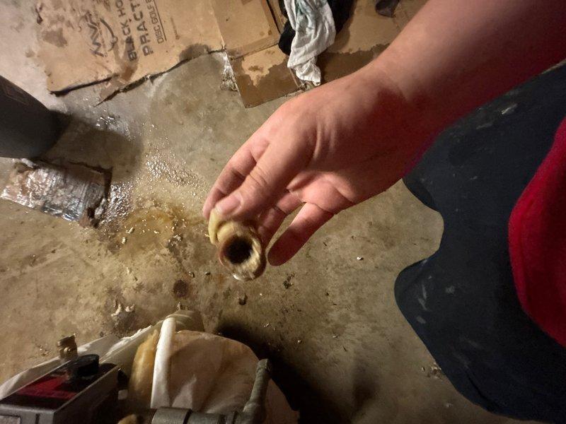 Responded to water heater leak in basement utility area. Upon arrival, found significant water pooling on concrete floor with visible staining and moisture damage throughout the space. Inspected water heater and identified leak originating from temperature and pressure relief valve assembly. The brass valve fitting showed signs of failure, causing active water discharge onto the floor. Assessed surrounding insulation and protective covering for water damage. Documented conditions with photographs showing extent of water accumulation and compromised valve component. Provided customer with findings and recommendations for relief valve replacement to resolve the active leak and prevent further water damage to the basement floor and surrounding area.
