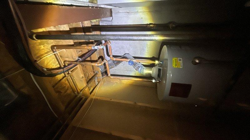 Performed plumbing maintenance inspection on residential water heater system. Conducted internal camera inspection of water heater tank to assess sediment buildup and interior condition, and documented copper supply line connections and plumbing configuration for maintenance records.