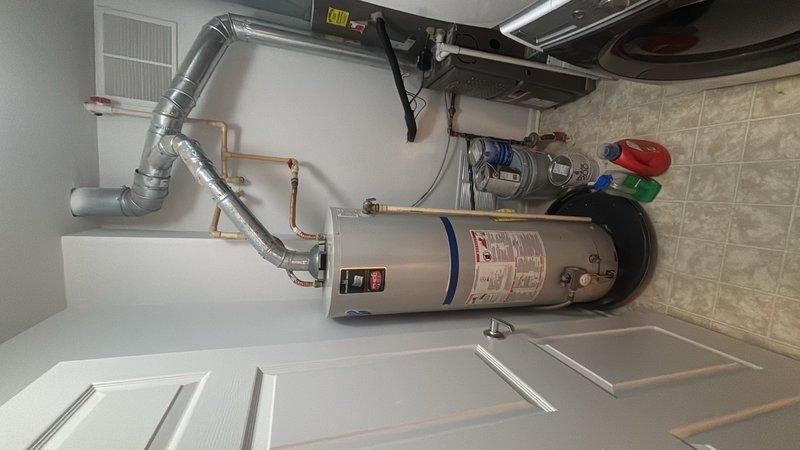 Completed on-site evaluation of existing gas water heater installation in condominium utility closet. Assessed current 40-gallon gas water heater unit, including inspection of gas supply lines, copper water connections with shutoff valves, and flexible vent ducting system routed to exhaust. Documented existing plumbing configuration, clearance requirements, and ventilation setup to provide accurate replacement estimate for new tanked water heater installation.
