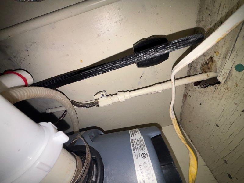 Responded to service call for kitchen sink with no water pressure. Upon inspection, diagnosed low water pressure issue at kitchen faucet. Examined under-sink plumbing configuration including garbage disposal unit, P-trap assembly, and supply line connections. Assessed existing faucet condition and water flow restrictions. Inspected all visible plumbing components beneath sink, including white PVC drainage system and connections to disposal unit. Verified proper operation of shut-off valves and checked for potential blockages or restrictions in supply lines. Documented existing plumbing configuration with cabinet-mounted components and mechanical systems for service records.