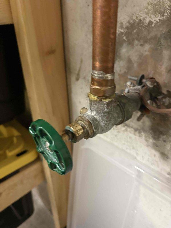 Responded to report of faulty main water shut off valve that was leaking and failing to properly shut off water supply. Upon inspection, found the existing gate valve with green wheel handle had deteriorated internal components causing both the leak and inability to achieve full closure. Replaced the defective main shut off valve with new brass ball valve assembly, utilizing proper copper pipe connections and fittings. Installed catch pan beneath valve assembly to protect against future leaks. Tested new valve installation for proper operation, confirming complete water shut off capability and verified no leaks at connections. System restored to full working order with reliable main water shut off control.