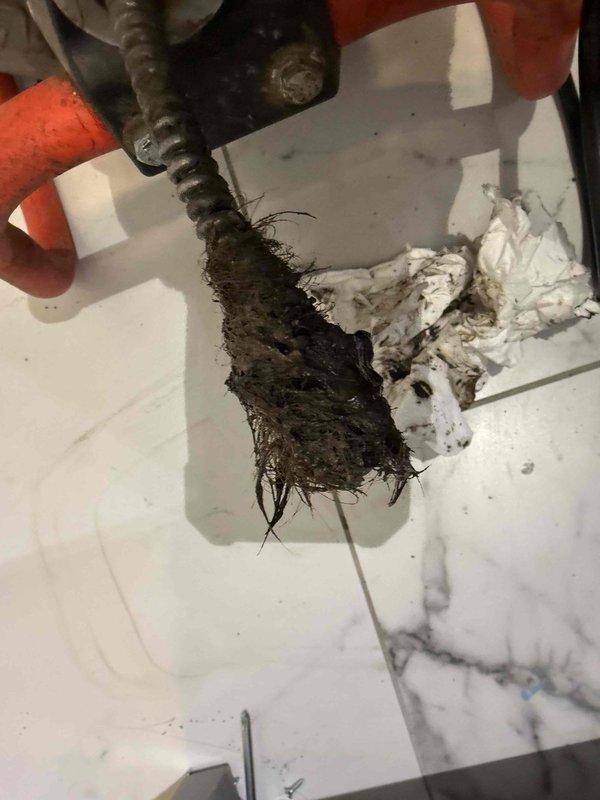 Responded to a clogged bathtub drain on the second floor hallway. Upon arrival, found the tub basin with significant standing water and visible debris accumulation in the drain opening. Utilized a mechanical drain auger to clear the obstruction, successfully removing a substantial amount of organic matter, hair, and fibrous buildup from the drain line. The blockage was completely cleared, restoring proper drainage function to the fixture.