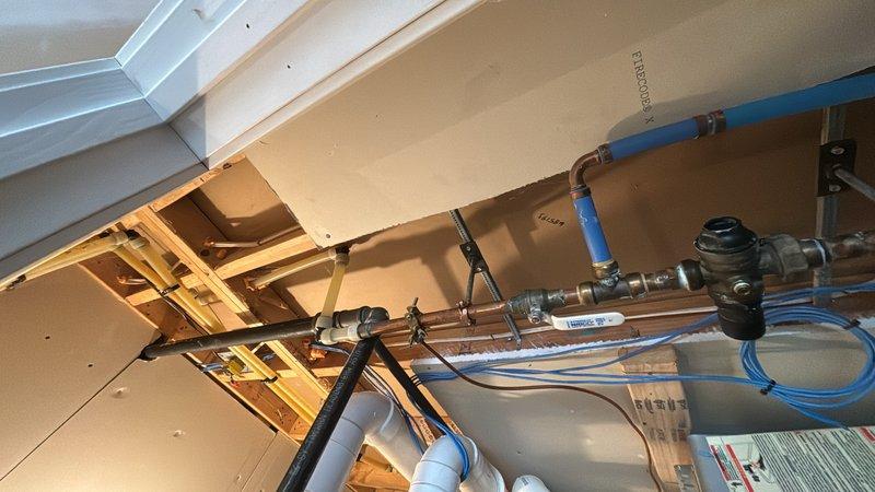 Completed scheduled plumbing maintenance visit including tankless water heater system flush and inspection. Serviced gas water heater installation with multiple shut-off valves, verified proper operation of pressure relief valve assembly, and inspected copper piping, PEX tubing, and gas line connections throughout the system. Performed maintenance on ceiling-mounted plumbing fixtures and verified all connections and mounting hardware were secure.