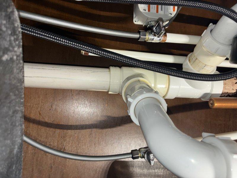 Responded to emergency water leak in kitchen area where supply line connected to shut-off valve had ruptured, causing active water discharge. Upon arrival, immediately located and isolated the water source to prevent further damage. Inspected the failed connection point at the shut-off valve and assessed the condition of surrounding plumbing components including flexible braided supply lines, PVC drain assembly, and associated fittings. Removed the compromised water line and replaced the faulty connection with new supply line and proper fittings. Verified all connections under the sink cabinet were secure and tested the system for leaks. Confirmed proper water flow and pressure restoration to the fixture while ensuring no additional leaks were present at valve connections or throughout the supply line assembly.