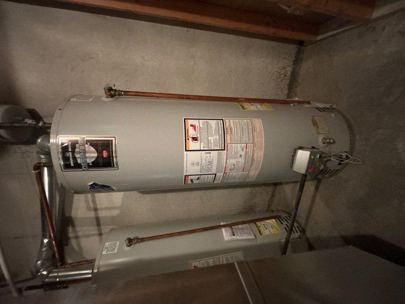 Responded to callback for no hot water issue. Upon inspection, found significant corrosion and deterioration on water heater piping system, including rust damage on curved copper sections and degraded insulation. Documented condition of water heater installation, including corroded pipework, electrical connections, and overall unit status for assessment and repair recommendations.