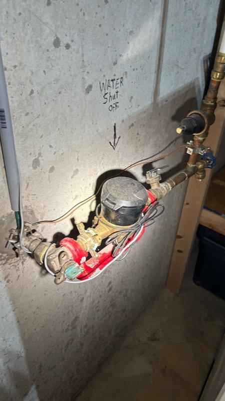 Completed comprehensive whole-home plumbing inspection in response to promotional campaign offer. Inspected main water shut-off valve assembly featuring dual brass valves with blue handles and associated copper piping connections. Examined pressure regulation system with chrome-plated pressure gauge and multiple connection points with color-coded plastic fittings. Assessed Whirlpool brand water heater installation including copper supply lines, flexible braided metal connectors with compression fittings, and proper safety shut-off valve configuration. All plumbing components, connections, and fixtures found to be in standard operating condition with no immediate concerns, leaks, or deficiencies identified during inspection.
