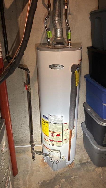 Completed comprehensive whole-home plumbing inspection in response to promotional campaign offer. Inspected main water shut-off valve assembly featuring dual brass valves with blue handles and associated copper piping connections. Examined pressure regulation system with chrome-plated pressure gauge and multiple connection points with color-coded plastic fittings. Assessed Whirlpool brand water heater installation including copper supply lines, flexible braided metal connectors with compression fittings, and proper safety shut-off valve configuration. All plumbing components, connections, and fixtures found to be in standard operating condition with no immediate concerns, leaks, or deficiencies identified during inspection.