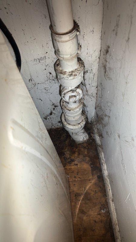 Responded to service call for clogged drain and broken pipe in basement bathroom area. Upon inspection, identified deteriorated PVC drainage pipe with significant corrosion at multiple connection points and rust-colored staining indicating age-related failure. Assessed water damage to surrounding wooden flooring and noted moisture deterioration at pipe joints. Provided estimate for pipe replacement, drainage repair, and toilet seal replacement to address reported clogging issue and prevent further water damage to basement area.