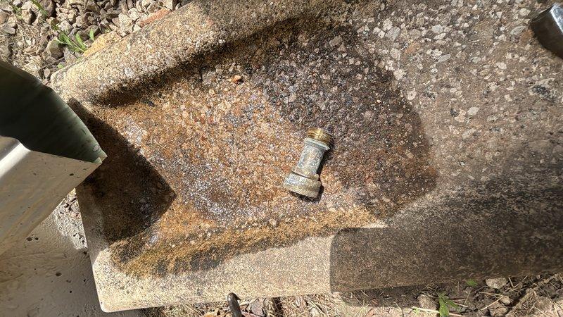 Responded to a leak at an exterior hose bibb on a 50-year-old residential property. Upon inspection, identified a failed valve stem and deteriorated packing causing water seepage at the faucet handle. Documented existing conditions with photos showing the outdoor faucet location and surrounding area with weathered concrete pavers and ground-level access points. Provided estimate for fixture repair or replacement to resolve the leak and restore proper function to the outdoor water supply.