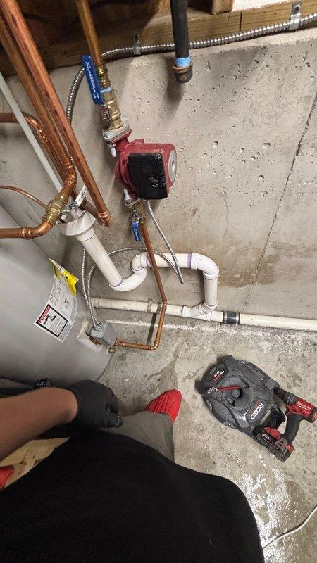# Plumbing Service - Main Drain Cleanout

Responded to reported clog in 2-inch PVC HVAC condensate drain line located in basement utility area. Upon arrival, assessed the drainage system routing from HVAC equipment through basement mechanical room to exterior discharge point. Located blockage in horizontal drain pipe run and performed mechanical cleanout using appropriate drain cleaning equipment. Cleared obstruction and restored proper drainage flow through PVC condensate line. Verified water flow from HVAC system drains freely to exterior without backup. Tested system operation to confirm complete resolution of drainage issue. Inspected surrounding plumbing infrastructure including tankless water heater, traditional tank water heater, copper supply lines, and circulation pump during service call. All mechanical systems in utility area observed to be functioning properly with no additional issues identified.