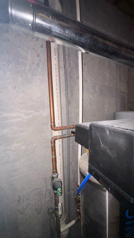 Responded to service call for malfunctioning water softener system in basement. Upon inspection, evaluated the existing water treatment equipment and associated plumbing connections including copper supply lines, PVC drainage piping, and electrical controls. Documented current system condition with photographs showing the water softener unit, control valve assembly, and integration with existing plumbing infrastructure. Assessed system performance issues and provided customer with options for repair versus replacement of the water conditioning equipment.