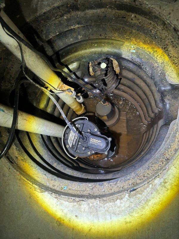 Responded to service call for malfunctioning sump pump system in basement. Upon arrival, performed comprehensive diagnostic inspection of existing sump pump installation housed in circular concrete basin. Tested pump operation, float switch functionality, and discharge system performance. Identified battery backup system requiring replacement due to degraded capacity. Installed new backup battery and power adapter to ensure continued operation during power outages. Verified proper pump cycling, water level activation, and discharge flow through existing PVC piping system. Confirmed all mechanical components, electrical connections, and backup systems functioning correctly under operational testing conditions.