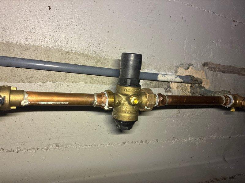 Responded to customer complaint of water hammer occurring at all faucets and toilets throughout the property. Inspected the main water supply system and identified inadequate or failed water hammer arrestor protection. Installed new pressure regulator with integral arrestor capabilities on the main water line to eliminate hydraulic shock and pressure spikes. Tested all fixtures following installation to confirm elimination of hammering noise and proper system operation.