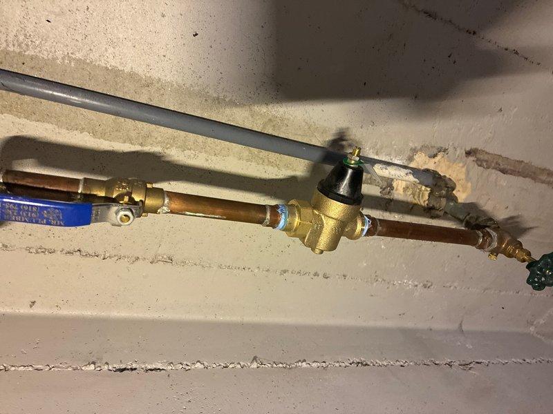 Responded to customer complaint of water hammer occurring at all faucets and toilets throughout the property. Inspected the main water supply system and identified inadequate or failed water hammer arrestor protection. Installed new pressure regulator with integral arrestor capabilities on the main water line to eliminate hydraulic shock and pressure spikes. Tested all fixtures following installation to confirm elimination of hammering noise and proper system operation.