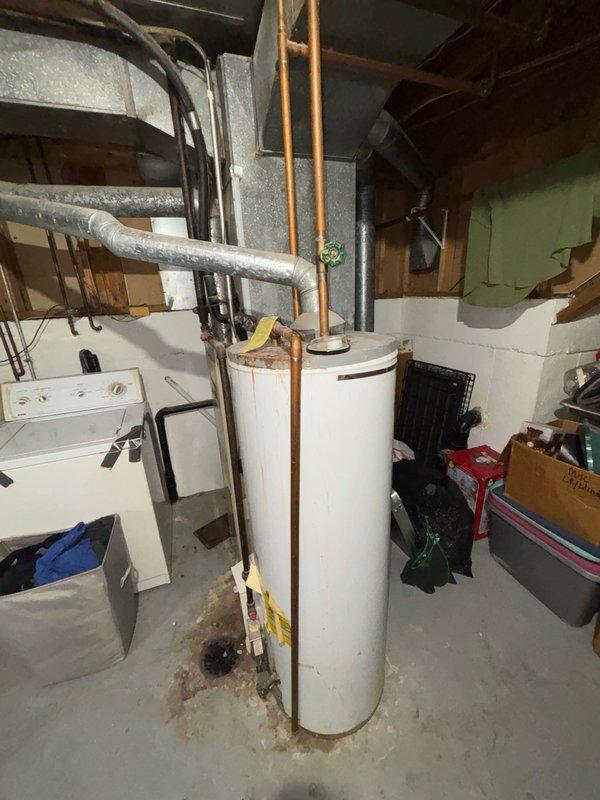 Conducted on-site evaluation of existing conventional tank-style water heater and basement utility infrastructure to provide tankless water heater replacement estimate. Assessed current plumbing configuration including copper supply lines, gas connections, venting requirements, and available clearances in utility area. Documented existing water heater location adjacent to laundry appliances and evaluated spatial constraints for tankless unit installation. Reviewed mechanical room layout including overhead pipe routing, electrical service accessibility, and proper ventilation pathways required for tankless system operation.