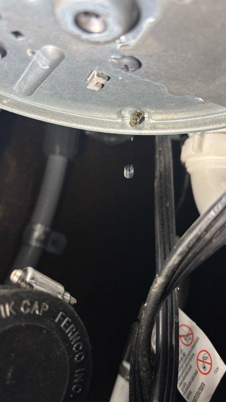 Responded to reported garbage disposal leak in kitchen. Upon inspection, identified active water dripping from disposal unit and surrounding plumbing connections. Examined under-sink plumbing assembly including P-trap configuration, PVC drainage pipes, and disposal mounting hardware. Assessed leak source at disposal unit and associated drain connections. Documented conditions with photographs showing water droplet formation and complete under-sink plumbing layout. Evaluated disposal unit for potential replacement needs and verified all drainage components and electrical connections for proper installation and functionality.
