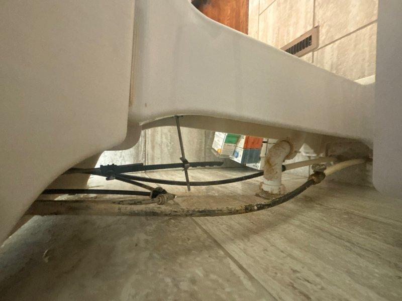 Responded to service call for ADA-compliant toilet and sink assessment in main bathroom. Upon arrival, performed thorough inspection of existing fixtures to evaluate options for achieving ADA height requirements. Examined plumbing connections, supply lines, and drain configuration to determine feasibility of replacement versus modification. Documented current installation with photographs showing water supply valve condition, noting corrosion on copper tubing that would require attention during any fixture replacement. Provided comprehensive estimate detailing costs for installing ADA-height toilet and sink fixtures, including necessary plumbing modifications and updated supply line connections to meet accessibility standards.