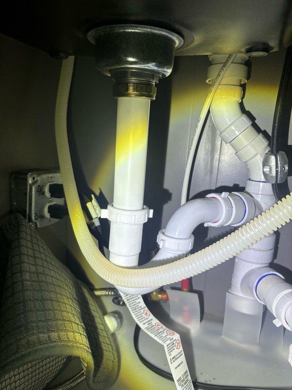 Performed routine plumbing maintenance inspection at residential property. Examined shower enclosure plumbing system, including ventilation grate functionality and shower fixture installation integrity in travertine-tiled bathroom. Inspected kitchen sink drainage system, verifying proper connection and secure mounting of chrome drain assembly, PVC tailpiece, and garbage disposal unit. Confirmed all drain hoses, including corrugated drainage lines, were properly secured with appropriate fasteners and free from leaks or blockages. All plumbing components found to be in satisfactory working condition with no immediate repairs required.