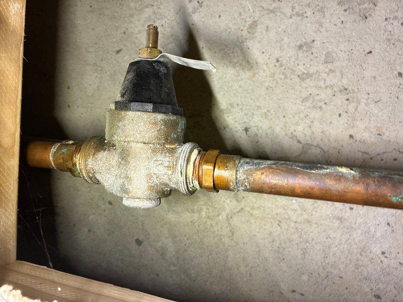 Responded to reported leak from 50-gallon water heater in basement. Upon inspection, identified leak originating from deteriorated pressure relief valve assembly, evidenced by significant corrosion and oxidation on copper piping and brass fittings. The General Electric water heater, manufactured February 2018, showed age-related wear on plumbing connections. Replaced faulty pressure relief valve, installed new brass fittings, and tested system for proper operation and seal integrity to resolve active water leak.