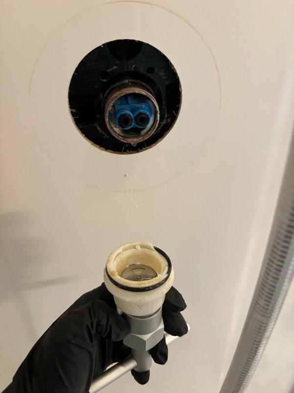 Responded to service call for leaking shower cartridge in bathroom. Upon arrival, inspected bathtub and shower assembly to identify source of leak. Removed existing drain components and cartridge assembly as documented in service photos. Customer had replacement cartridge on-site. Installed new shower cartridge, tested for proper operation and verified leak was resolved. Cleaned work area and ensured all plumbing fixtures were functioning correctly before completing service.
