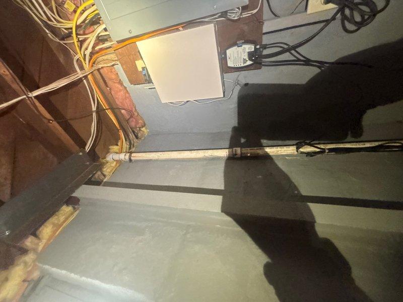 Responded to service call for sump pump reported as not operating correctly in basement. Upon inspection, verified existing sump pump functionality and assessed discharge line routing from basement to exterior. Confirmed discharge line was properly positioned and draining away from foundation, with hose extending across concrete walkway into landscaped area. System tested and operating within normal parameters at time of service completion.