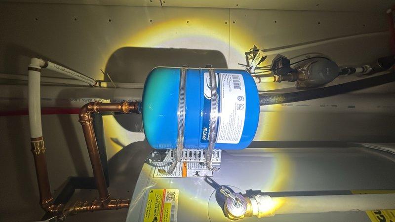 Completed plumbing inspection of water heater installation and under-sink supply line connections. Documented existing copper piping, pressure vessel with securing bands, brass fittings, and flexible supply lines with shut-off valves in proper working condition.