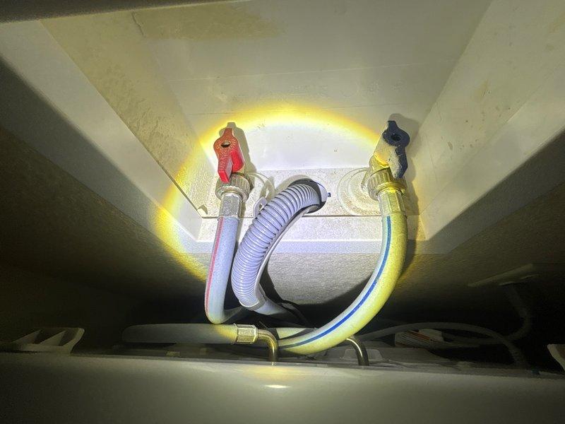Completed plumbing inspection of water heater installation and under-sink supply line connections. Documented existing copper piping, pressure vessel with securing bands, brass fittings, and flexible supply lines with shut-off valves in proper working condition.
