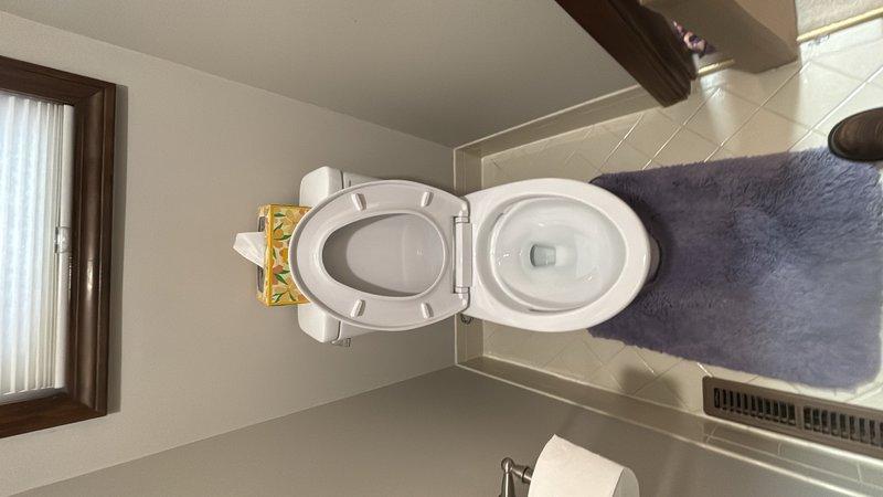 Completed toilet installation in residential bathroom. Installed new white toilet unit with proper mounting and sealing to tiled floor. Note: Toilet seat may require replacement or adjustment to ensure correct fit and model compatibility with installed fixture.