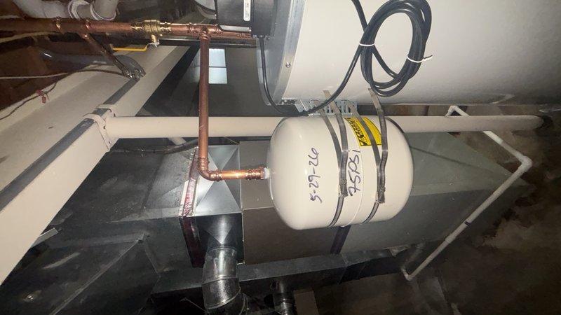 Completed installation of a 75-gallon tall gas water heater in attic space, replacing existing unit. Installed new 4-gallon expansion tank and relocated it to mount directly on the water heater tank for improved accessibility and code compliance. Connected all copper supply lines, gas piping, and venting systems with proper brass fittings and valves to ensure safe and efficient operation.