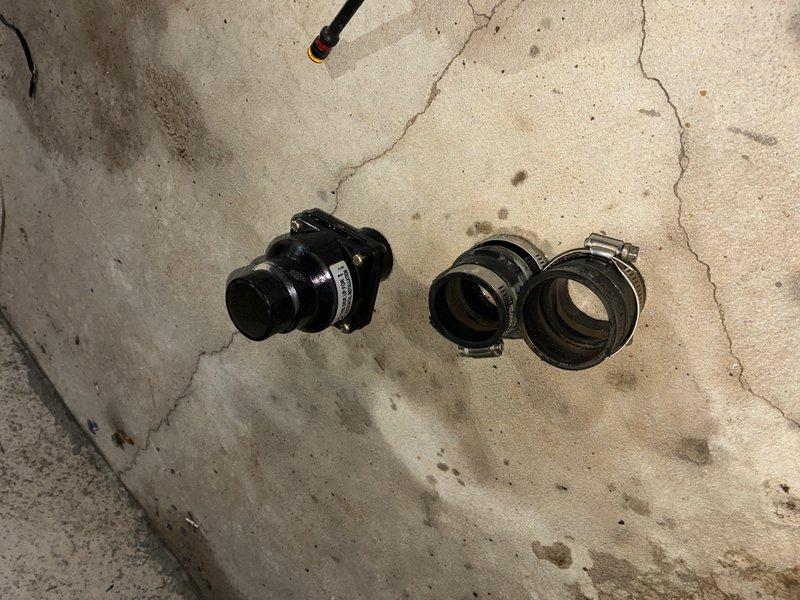 Responded to emergency recall for sump pump failure with water discharge issue. Upon arrival, found disconnected discharge piping at PVC coupling connection, causing water to spray from the apparatus. Customer had unplugged the unit to stop the discharge, resulting in pit refilling. Inspected the 16-year-old system and identified failed connection components. Replaced defective coupling and flexible connectors with new rubber connectors and secured with metal band clamps. Reassembled discharge piping, tested system operation, and verified proper water evacuation with no leaks at connection points.