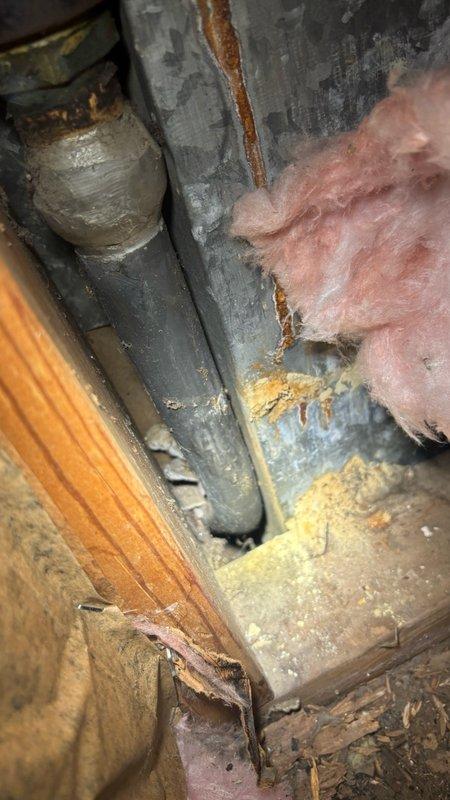 Responded to service call for reported water leak under bathroom sink and drainage issues. Upon inspection, examined white PVC P-trap assembly and drain connections for signs of leakage and obstruction. Assessed plumbing fixture mounting and verified proper installation of trap components and threaded connections. Inspected accessible crawl space and attic areas to evaluate potential water damage, checking ductwork, insulation, and structural framing for moisture intrusion or corrosion. Documented existing conditions including rust streaking on metal ductwork and fiberglass insulation status. Provided professional assessment and second opinion on plumbing system condition to assist with repair decision-making.