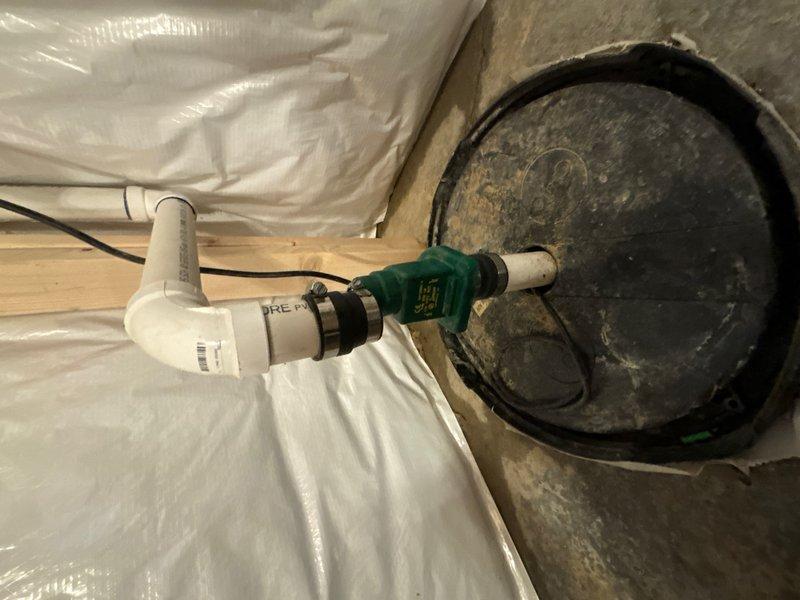 Responded to report of small puddle on floor near existing sump pump in basement. Upon inspection, found significant debris and grime accumulation in sump pit with water pooling at bottom. Discharge piping system showed signs of age and wear, with corroded metal components visible in the assembly. Checked pump operation, float switch mechanism, and PVC discharge line configuration including elbow connections and check valve. Documented conditions of pit liner, pump housing, and associated plumbing components. Moisture barrier and vapor sheeting in surrounding crawl space area appeared intact. Assessed overall system functionality and identified necessary repairs to address water accumulation issue and restore proper sump pump operation.