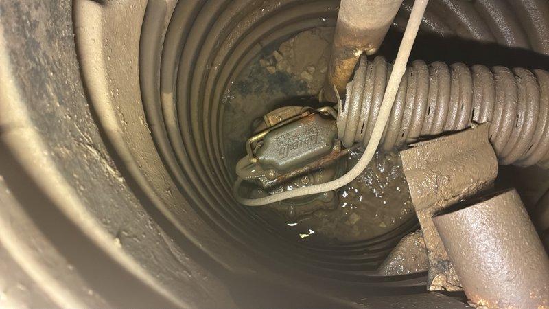 Responded to basement flooding issue following recent rainfall. Upon inspection, found existing sump pump basin with standing water and visible sediment accumulation. Assessed pump functionality, discharge line connections, and basin condition. Corrugated flex hose and piping connections showed signs of age with dust buildup present throughout the system.