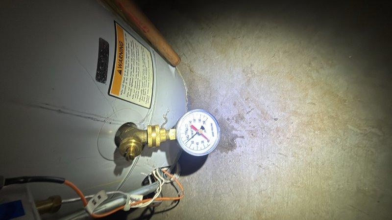 Responded to basement water heater leak on unit approximately 20 years old. Performed on-site assessment of 50-gallon gas water heater showing signs of age-related deterioration and active leaking while still maintaining hot water production. Inspected all plumbing connections, pressure relief valve, gas lines, and copper piping configuration. Documented existing installation including HVAC integration, pressure gauge readings, and overall system condition. Provided estimate for water heater replacement with new 50-gallon gas unit including proper venting, gas line connections, and code-compliant installation.